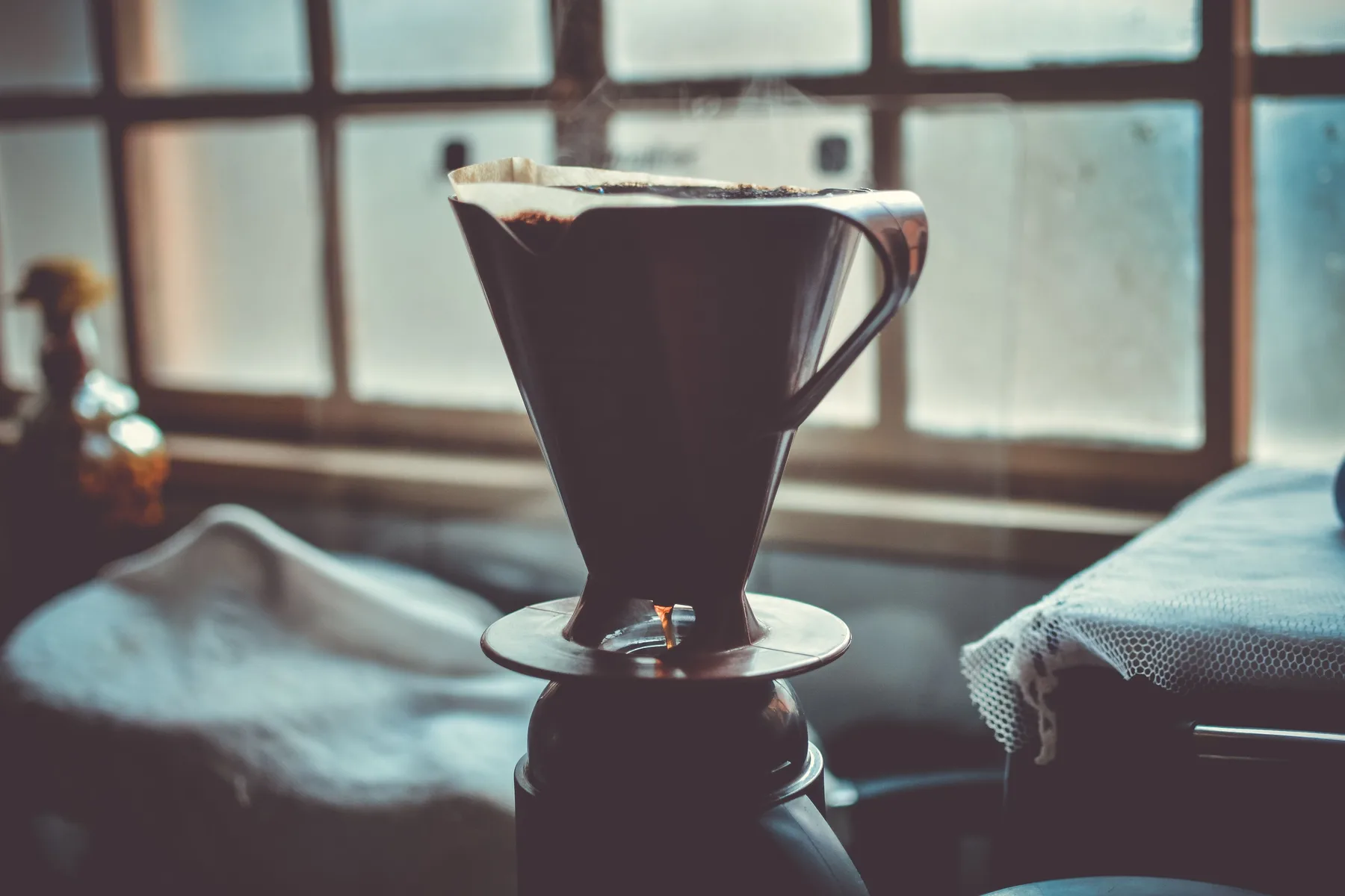 A pour-over coffee finishing by a window in a calm home setting
