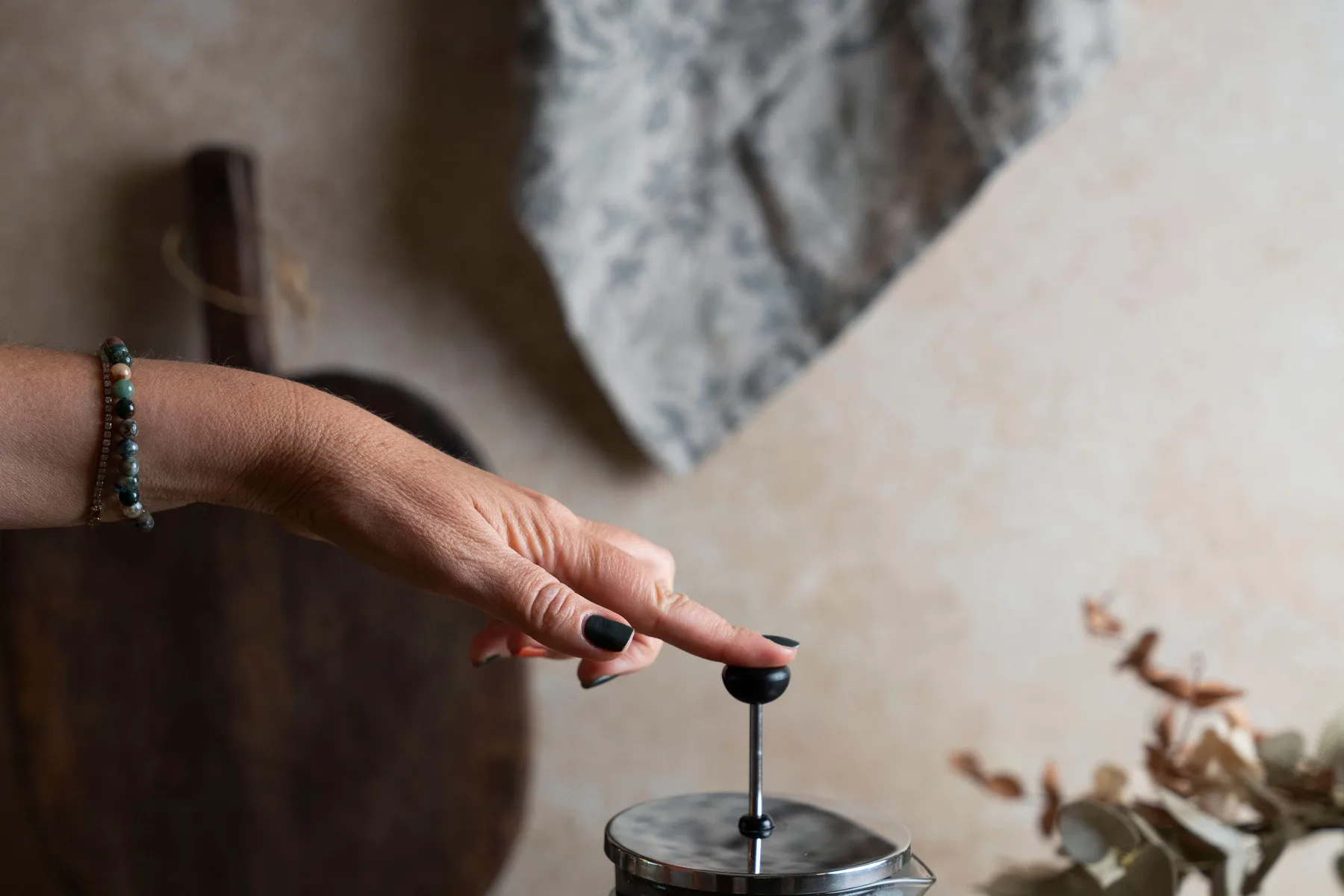 A hand slowly pressing the plunger on a French press